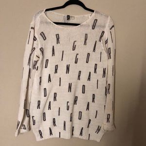 white and black knit sweater (Spells out “DARING”)